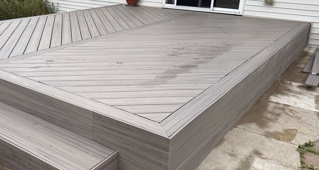 Close view of composite decking, mitered picture-frame border, fascia, and step
