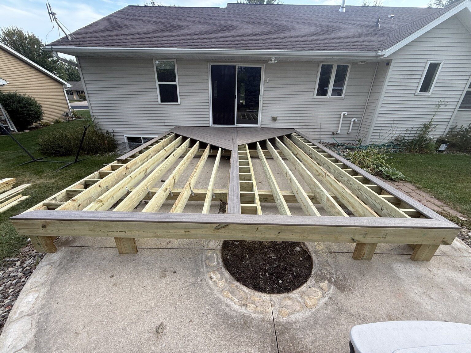 Pressure-treated deck framing with composite picture-frame border during construction