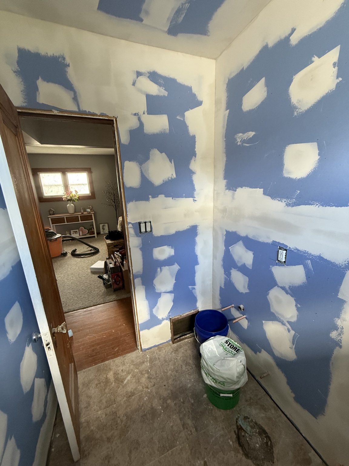 Interior room during drywall finishing with taped seams and joint compound