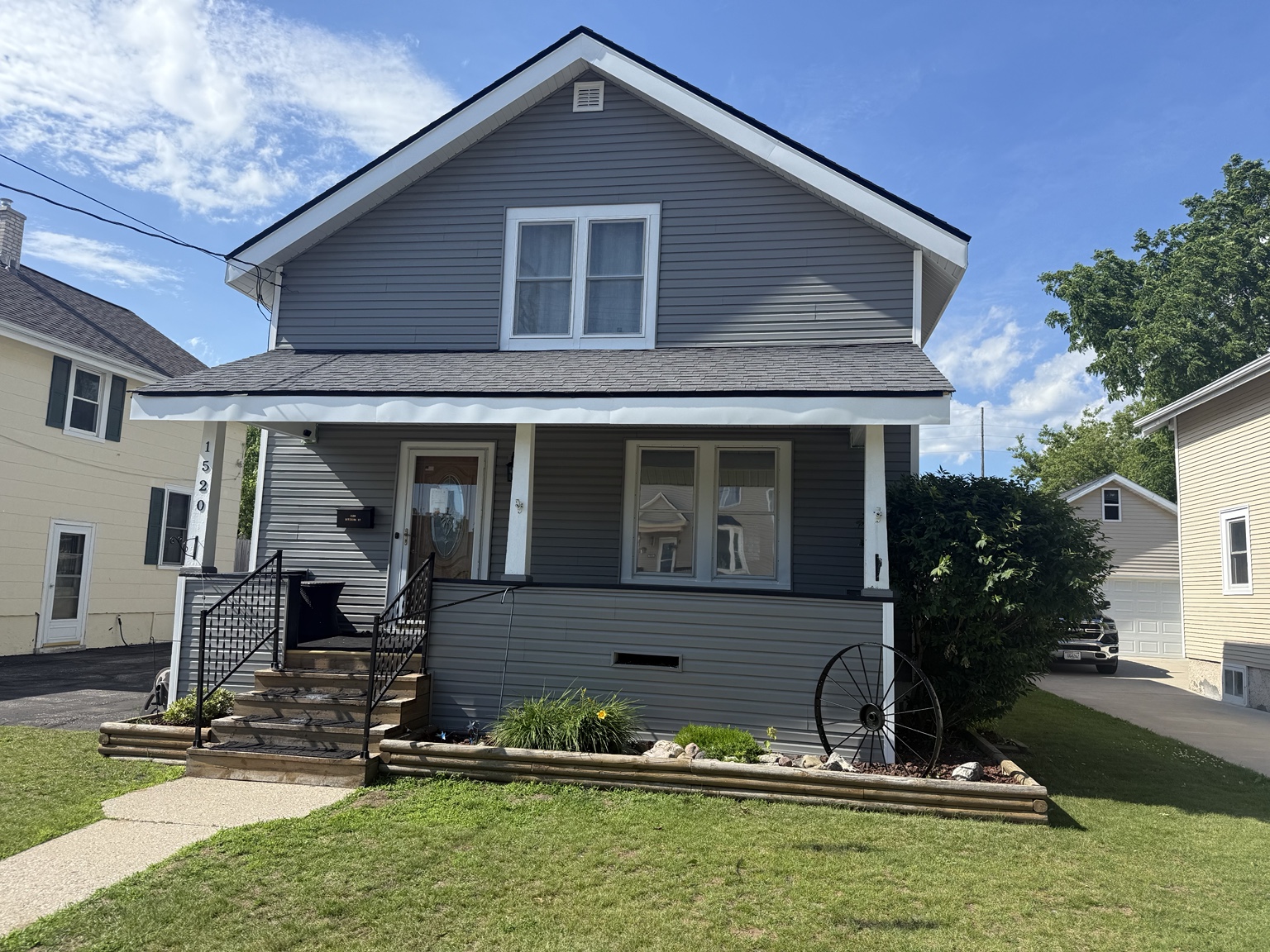 Front view of a two-story home with gray horizontal siding and white exterior trim