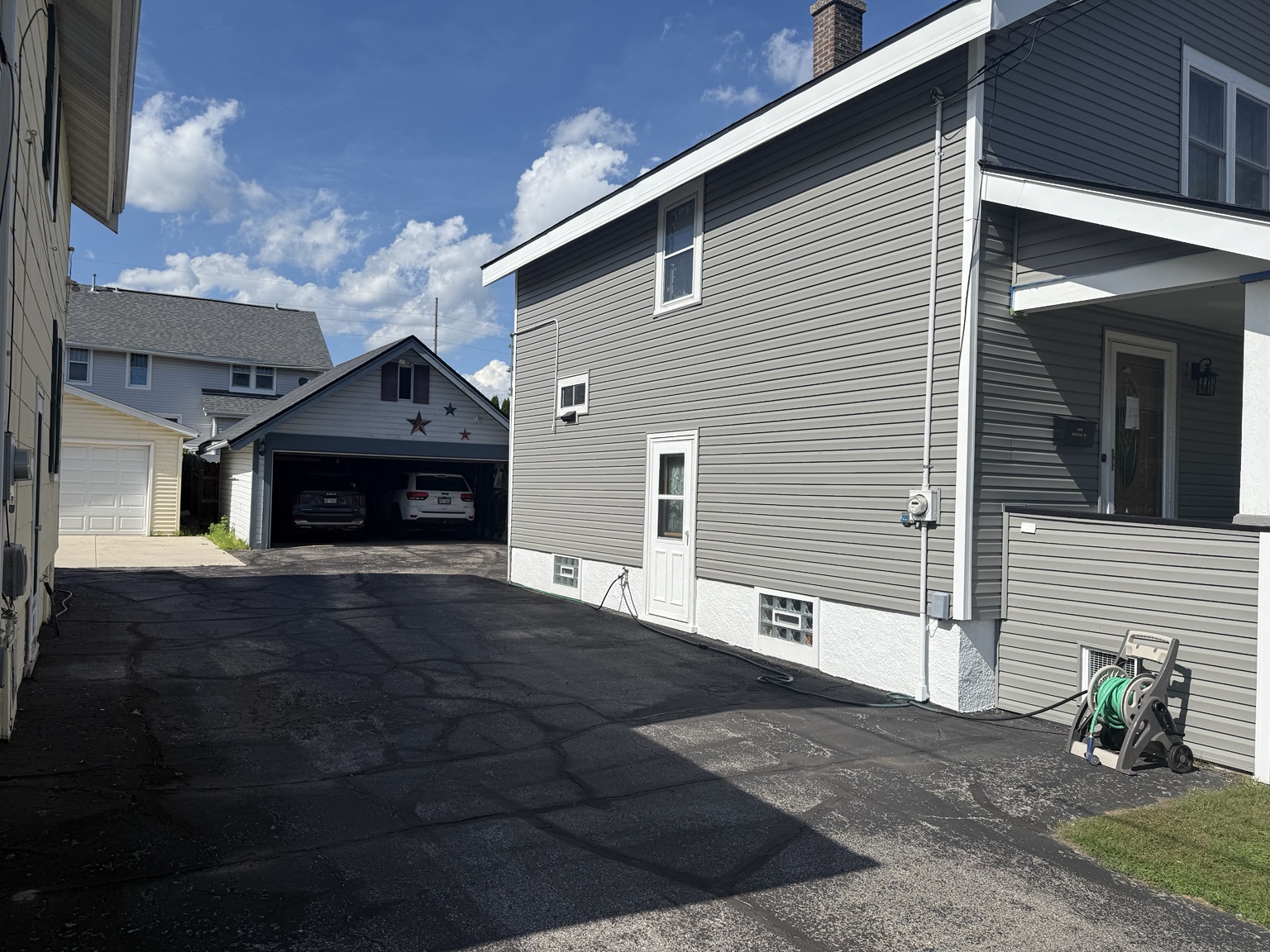 Side view of gray horizontal siding with white window and corner trim