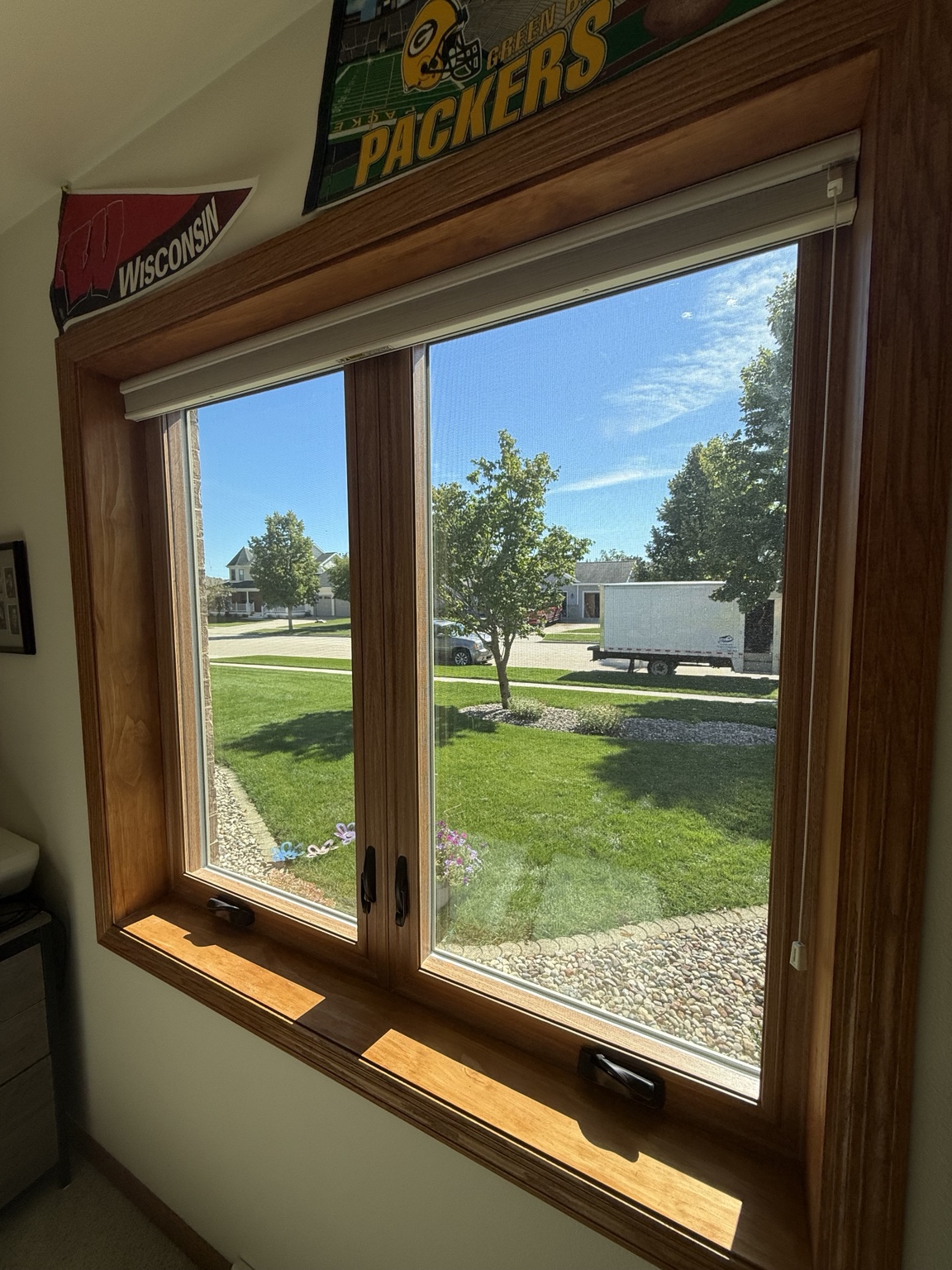 Interior view of twin casement windows with wood trim, sill, and crank handles